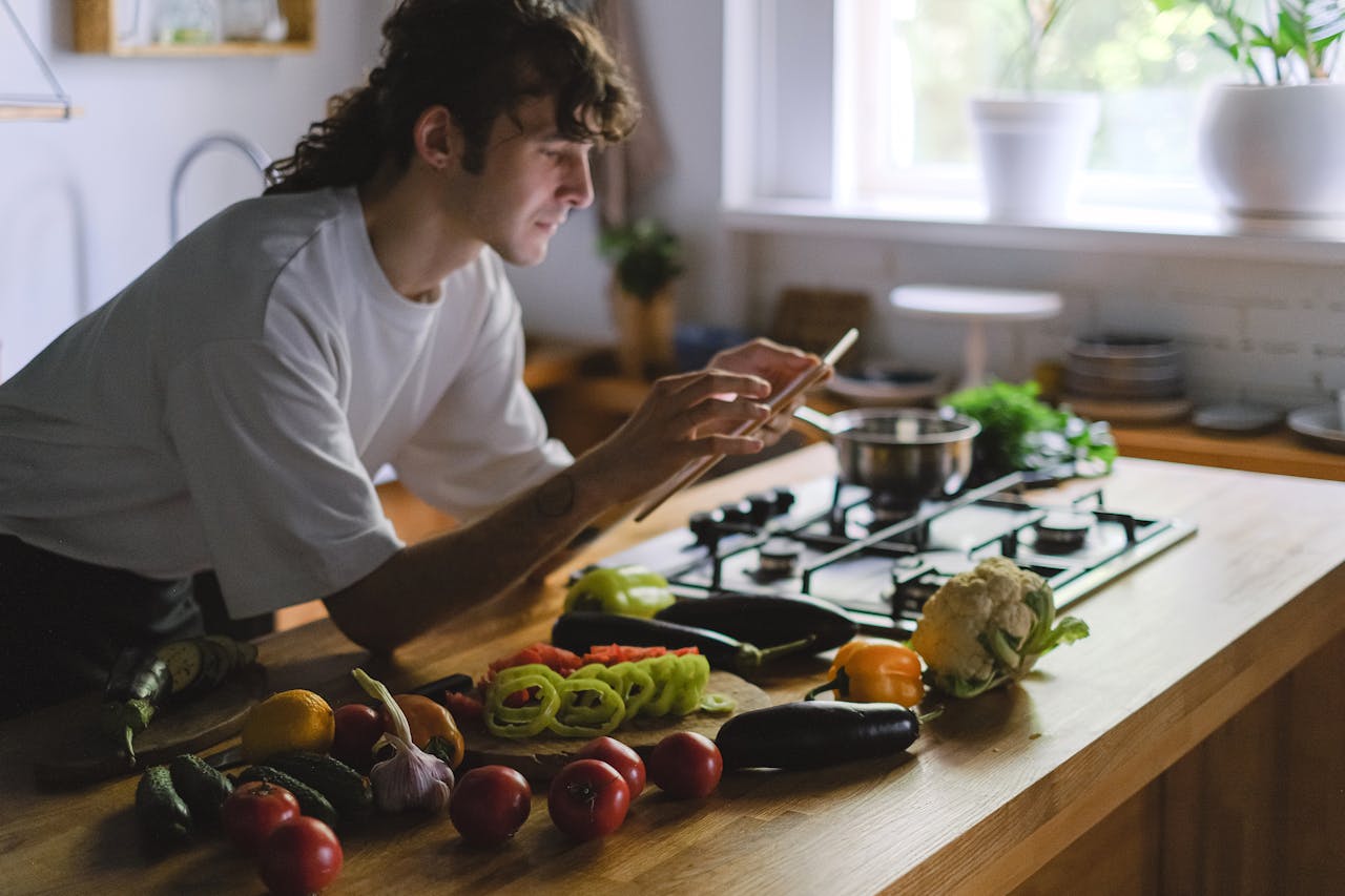 gallery-03 A young chef captures fresh vegetables on a kitchen counter for a blog post.