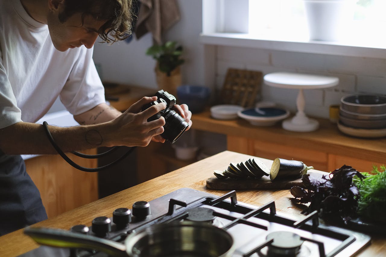 gallery-05 A photographer captures a sliced eggplant and greens in a stylish kitchen environment.